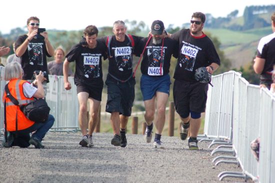 Kevin Pennell (second from left) is helped over the finish line by his team mates at The Nugget Multisport Festival, after completing his stage with a broken leg.